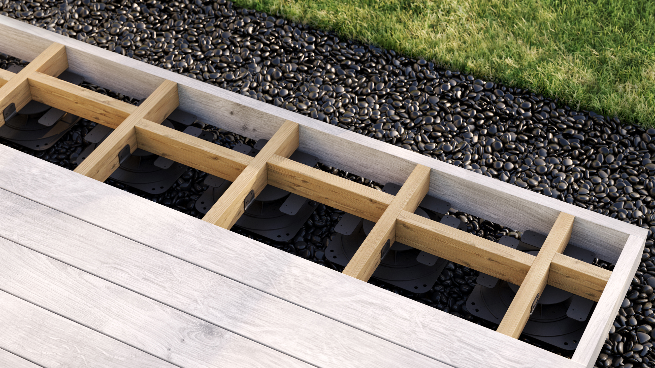 The lower workings of a deck are exposed in the image. There are panels, except towards the end of the deck, which sits atop gravel. There is grass shown in the top right of the image. 