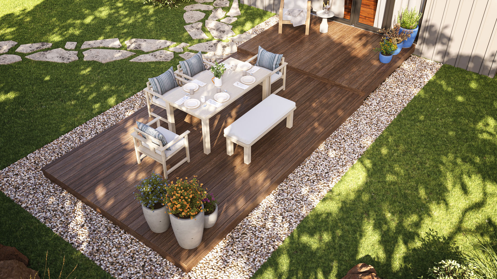The image is taken from an aerial view, showing an outdoor seating area. There is a deck that is embedded in a gravel area, surrounded by grass.